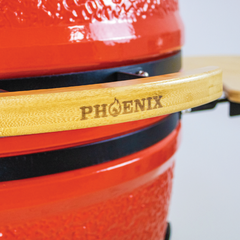 Red barbecue grill with a wooden handle featuring 'PHOENIX' branding.